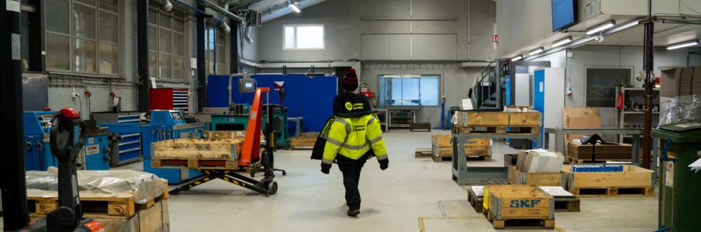 Työntekijä kävelee tuotantotilassa